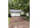 Exterior view featuring a two-car garage, driveway, and greenery around the house at 425 Rockingham Ln, Woodstock, GA 30189