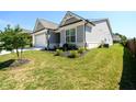 Exterior side view of a gray single-Gathering home, with tidy landscaping and green lawn at 2856 Knob Creek Dr, Snellville, GA 30078