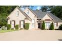 Charming brick home showcasing manicured bushes, dark shutters, a well-maintained lawn, and a spacious driveway at 255 Carriage Station Dr, Lawrenceville, GA 30046