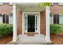 Covered front entry featuring a classic black door flanked by sidelights and brick columns at 118 Brendylynn Trce, Woodstock, GA 30188