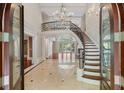 Grand foyer with a sweeping staircase, elegant chandelier, and gleaming marble floors at 760 River Gate Dr, Atlanta, GA 30350