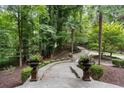 Landscaped stone pathway leading to a home with lush trees and manicured bushes at 760 River Gate Dr, Atlanta, GA 30350