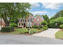 Charming brick home features a manicured lawn, mature trees and a long driveway at 151 Overhill Point, Alpharetta, GA 30005