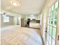 Bright living room featuring new carpet, stainless steel appliances, and access to outdoor patio at 4363 Stonewall Tell Rd, Atlanta, GA 30349