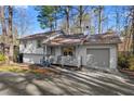 Charming split-level home featuring a metal roof, one car garage, and a cozy front porch at 7000 Woodland Nw Pl, Kennesaw, GA 30152