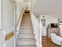 Inviting foyer with a carpeted staircase and wood floors that leads into a beautifully decorated living area at 162 Lablanc Nw Way, Atlanta, GA 30327