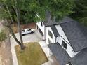 Aerial view of a white, two-story home with a dark roof and a large driveway at 2764 Midway Rd, Decatur, GA 30030