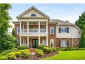 Charming two-story brick home with a classic front porch, manicured lawn and mature landscaping at 5173 Brendlynn Dr, Suwanee, GA 30024