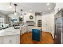 Open kitchen with granite countertops, a central island, stainless steel appliances, and hardwood floors at 5173 Brendlynn Dr, Suwanee, GA 30024