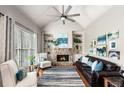 Cozy living room with stone fireplace, built-in shelving, a leather sofa and a vaulted ceiling at 5173 Brendlynn Dr, Suwanee, GA 30024