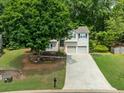 Traditional two-story home with mature trees, well-kept lawn, stone accents, and a two-car garage at 2623 Lone Oak Nw Trl, Kennesaw, GA 30144