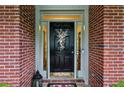 Elegant front door with decorative wreath, sidelights and brick surround, offering a warm welcome at 107 W Point Trl, Woodstock, GA 30189