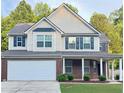 Charming two-story home featuring brick accents, a covered porch, and a well-maintained front yard at 5421 Skylar Creek Ln, Buford, GA 30518