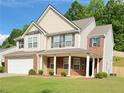 Beautiful two-story home featuring brick accents, vinyl siding, a front porch, and a well-manicured lawn at 5421 Skylar Creek Ln, Buford, GA 30518