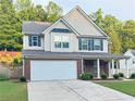 Two-story home featuring brick accents, a covered porch, well-maintained lawn, and a two-car garage at 5421 Skylar Creek Ln, Buford, GA 30518