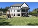Large backyard featuring a playground and a covered back porch with stairs leading to the yard at 1952 Azalea Dr, Lawrenceville, GA 30043