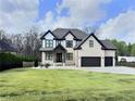 Beautiful two-story brick house featuring black trim accents, a well-maintained lawn and a three car garage at 1952 Azalea Dr, Lawrenceville, GA 30043