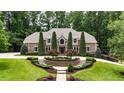 Beautifully landscaped home featuring a lush green lawn, mature trees, and manicured shrubs at 4995 Aviary Nw Dr, Acworth, GA 30101