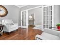 Elegant living room showcasing hardwood floors, French doors, and neutral decor, creating a bright and airy atmosphere at 5365 Vendelay Ln, Cumming, GA 30040