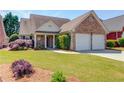 Well-kept brick home with a two-car garage, lush lawn, and inviting front porch at 836 Windsor Place Ct, Grayson, GA 30017