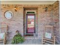 Inviting front porch with rocking chairs, brick walls and decorative plants at 836 Windsor Place Ct, Grayson, GA 30017