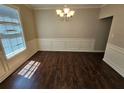 Dining room featuring hardwood floors, modern lighting, and wainscoting at 1021 Rock Elm Dr, Auburn, GA 30011
