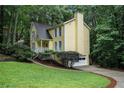 Well-maintained home with a lawn, mature landscaping, and a driveway leading to a garage at 1879 Beaver Dam Ne Ln, Marietta, GA 30062