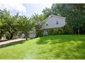 Split-level home featuring a front yard with mature trees in a green, lush surrounding at 1112 Mountain Springs Nw Dr, Kennesaw, GA 30144