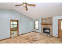 Living room features a stone fireplace, ceiling fan, and natural light from two windows at 1112 Mountain Springs Nw Dr, Kennesaw, GA 30144
