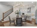 Elegant dining area with modern lighting and a view into the stylish kitchen at 124 Everley Walk, Alpharetta, GA 30009