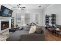 Cozy living room featuring a fireplace, plush sectional sofa, and abundant natural light at 124 Everley Walk, Alpharetta, GA 30009