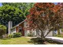 View of side and front of home with brick chimney and an attached two car garage at 1100 Ashbury Dr, Decatur, GA 30030