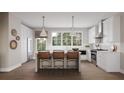 Well-lit kitchen featuring stainless appliances, white cabinets, a breakfast bar with pendant lighting, and wood flooring at 1348 Grannysmith Trce # 39, Brookhaven, GA 30319