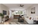 Bright open-plan living room flowing into a modern kitchen, featuring hardwood floors, a ceiling fan, and recessed lighting at 1348 Grannysmith Trce # 39, Brookhaven, GA 30319