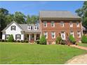 Classic brick and siding home with well-manicured lawn and landscaping and brick stairway to main entrance at 1811 Murdock Rd, Marietta, GA 30062