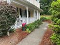Inviting front porch with white railing, beautiful landscaping, and a cozy seating area at 750 Providence Dr, Lawrenceville, GA 30044