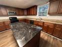 Well-appointed kitchen featuring an island with a granite countertop and wood cabinets at 1095 S Burnt Hickory Rd, Douglasville, GA 30134