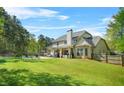 Expansive backyard featuring a well-maintained lawn, covered patio, and a sparkling pool, perfect for outdoor entertaining at 229 Primstone Way, Mcdonough, GA 30253