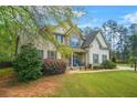Charming two-story home with a well-manicured lawn, stone accents, and inviting front porch with blue chairs at 229 Primstone Way, Mcdonough, GA 30253
