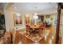 Dining room with chandelier, hardwood floors, area rug, and view into modern kitchen at 440 Canton Walk, Roswell, GA 30075