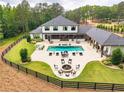 Aerial view of backyard featuring a pool, covered outdoor living space, and lush greenery at 6301 New Bethany Rd, Buford, GA 30518