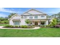 Charming two-story modern farmhouse with a welcoming front porch, black-trimmed windows, and meticulously manicured landscaping at 6301 New Bethany Rd, Buford, GA 30518