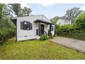 Cozy home with well-maintained lawn, black accents, and a paved driveway leading to the entrance at 1268 Ladd Sw St, Atlanta, GA 30310