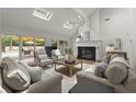 Bright living room with a fireplace, skylights, and sliding doors to the outdoor deck at 1678 Rabke Rd, Canton, GA 30114