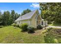 Well-maintained home with light yellow siding, pretty landscaping, and a gray metal roof at 3357 Saddleton Way, Douglasville, GA 30134