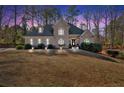 Inviting exterior view of home featuring manicured lawn and professional outdoor lighting at 4990 Sawgrass Nw Pl, Acworth, GA 30102