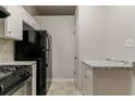 Functional kitchen boasts granite countertops, black appliances, and ample cabinet storage at 4905 Sandberg Ct, Stone Mountain, GA 30088