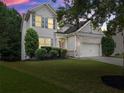 Two-story home boasts manicured lawn, complementing mature trees and well-kept landscaping at 6160 Overleaf Ter, Cumming, GA 30040