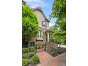 Beautiful home featuring a brick facade, landscaped front yard, and a cozy front porch with staircase and iron gate at 148 Canton St, Alpharetta, GA 30009