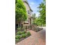 Beautiful home featuring a brick facade, landscaped front yard, and a cozy front porch with staircase and iron gate at 148 Canton St, Alpharetta, GA 30009